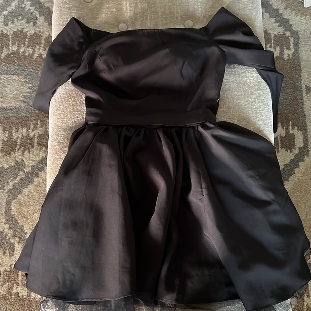 Black off the shoulder dress. With sleeves that go mid way down the arm.